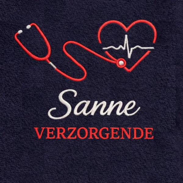 Borduring op marine fleece: rode stethoscoop, naam Sanne en tekst "VERZORGENDE".
